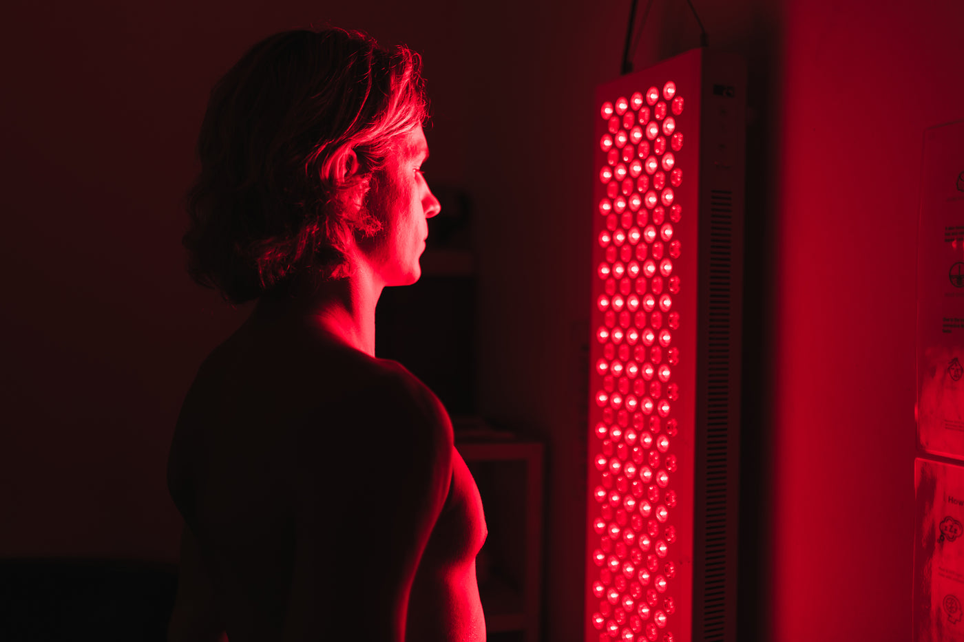 standing in front of red light therapy panel